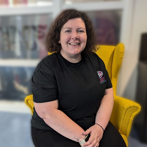 Amy Monks sitting in yellow chair in front of students' association office