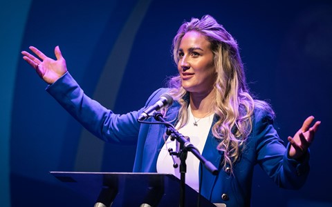 Sheli McCoy with arms open talking to the audience at the start of RESPECT Week