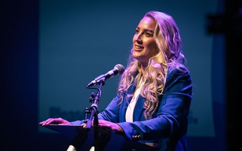 Sheli McCoy standing on the stage at the Gardyne Theatre giving her speech to students and staff at Dundee & Angus College