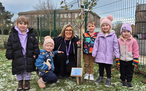 Nursery children planting a tree