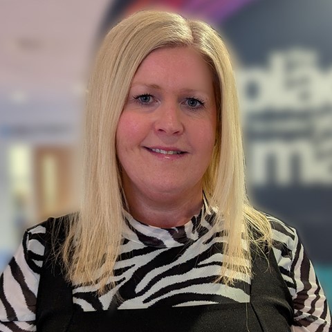 Woman smiling standing in college reception area