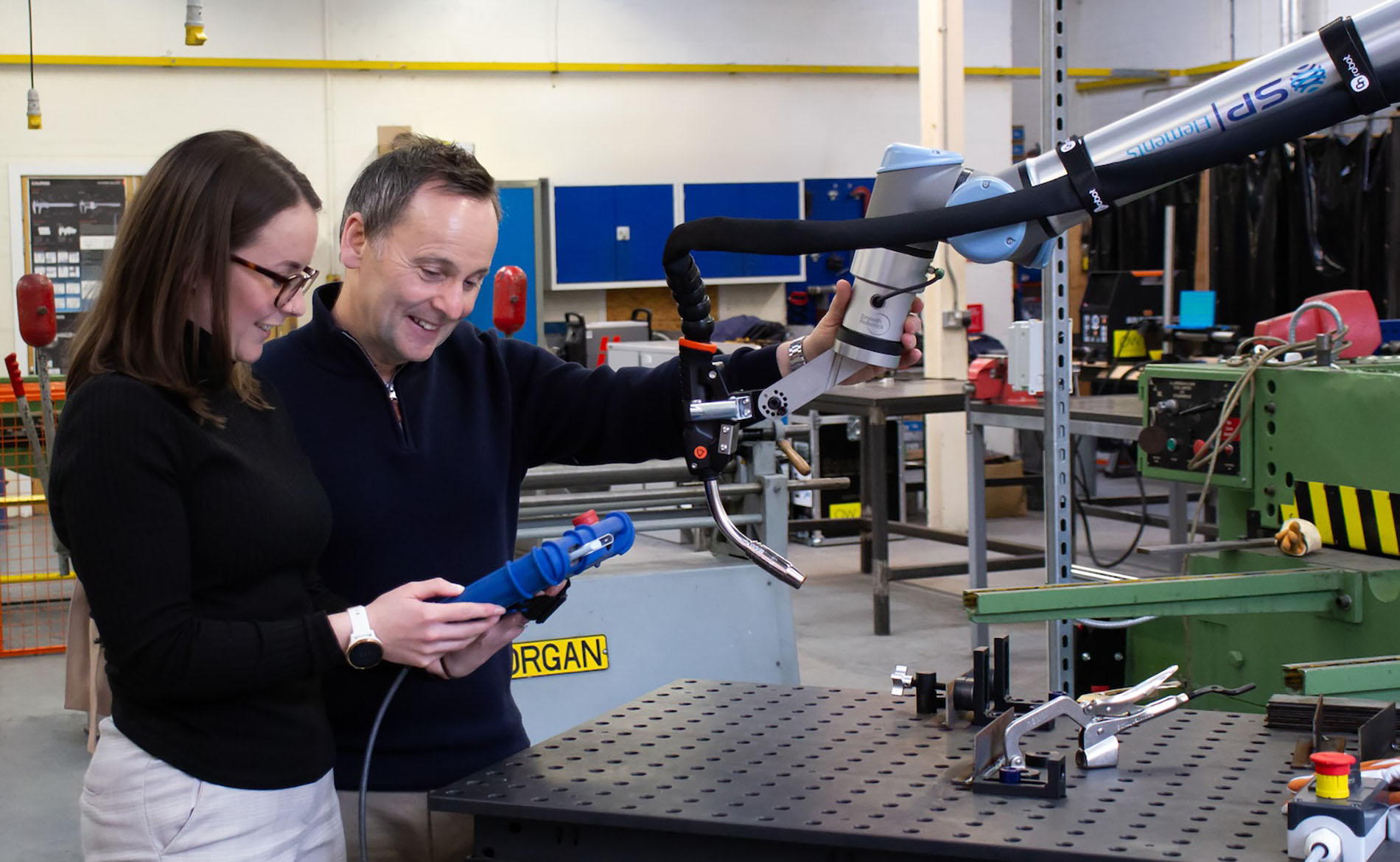 Helen Ritchie and Stuart Robertson operating a welding cobot. )