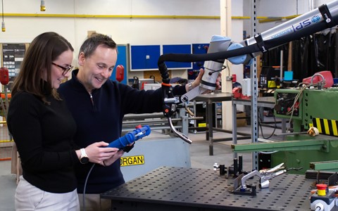 Helen Ritchie and Stuart Robertson operating a welding cobot.
