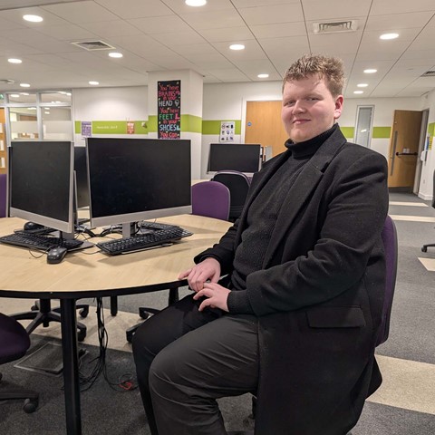Student Lewis sitting at desk