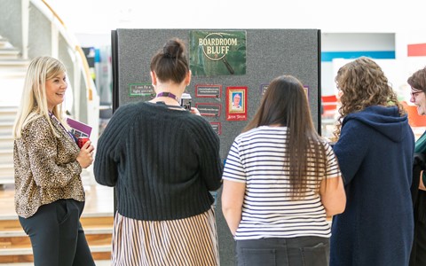 A group of staff at the 2025 staff awards playing a game called 'boardroom bluff'