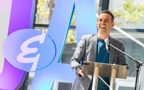 A staff member laughs as they present awards on stage