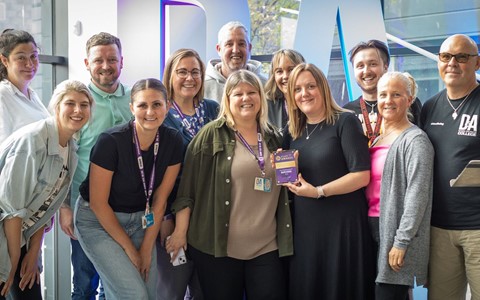 group photo of award winners on stage with their staff award