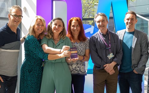group photo of award winners on stage with their staff award