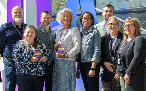 group photo of award winners on stage with their staff award