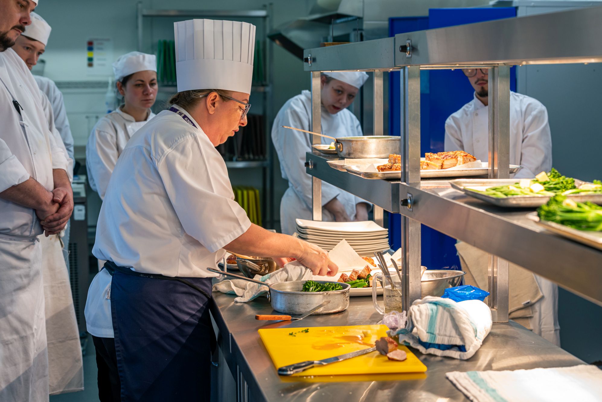 Hospitality students in a kitchen wearing chefs whites
