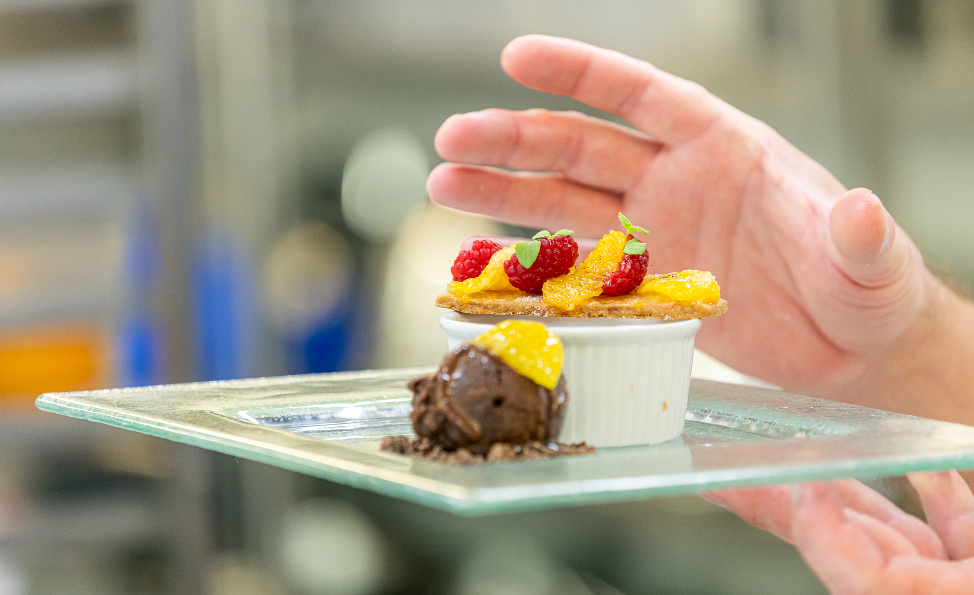 Close up of hand placing dessert on plate