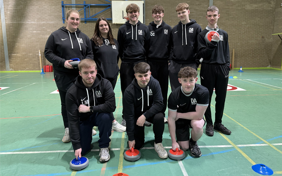 Group of sports students holding curling stones