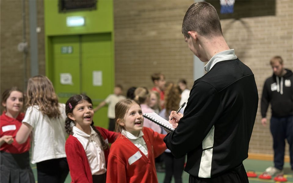 Sports student talking to school pupils