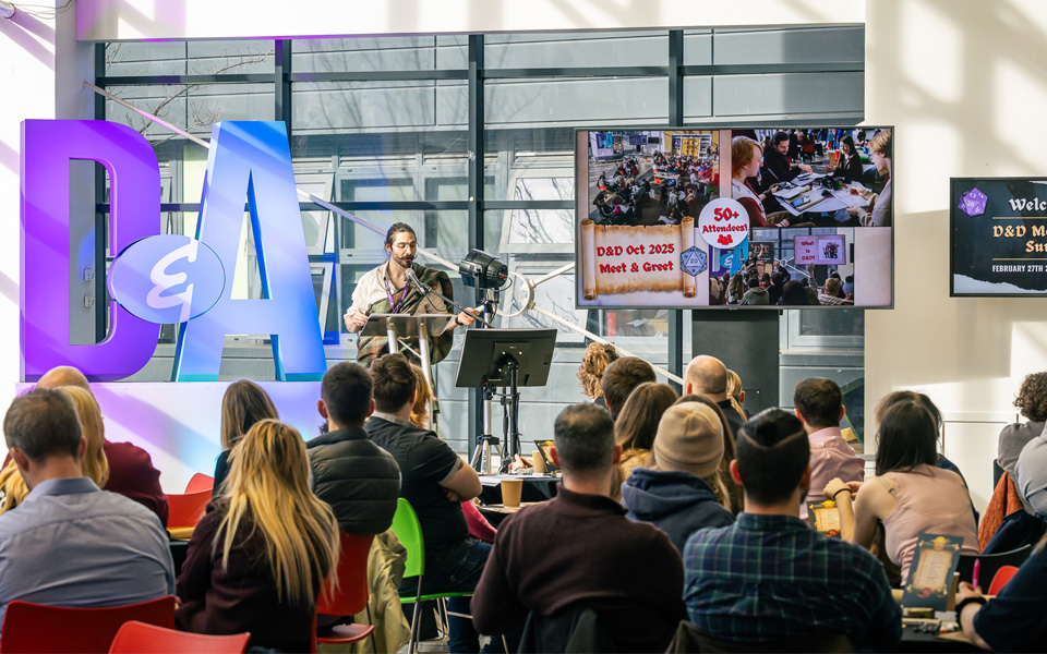Staff member on stage introducing Dungeons and Dragons Summit event