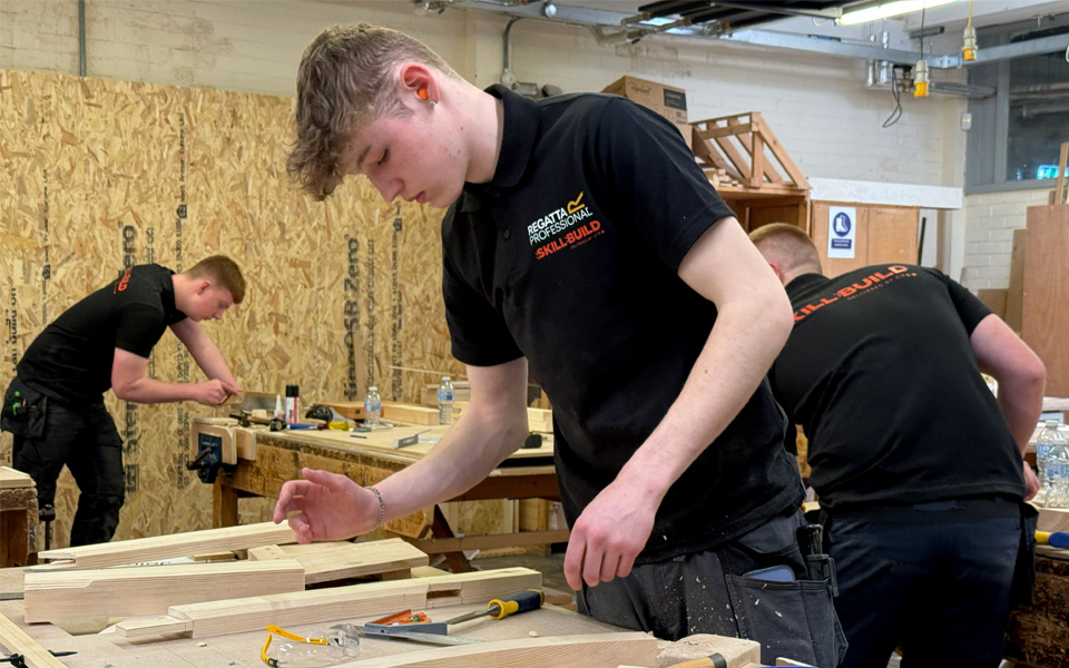 Joinery student at work bench looking at work