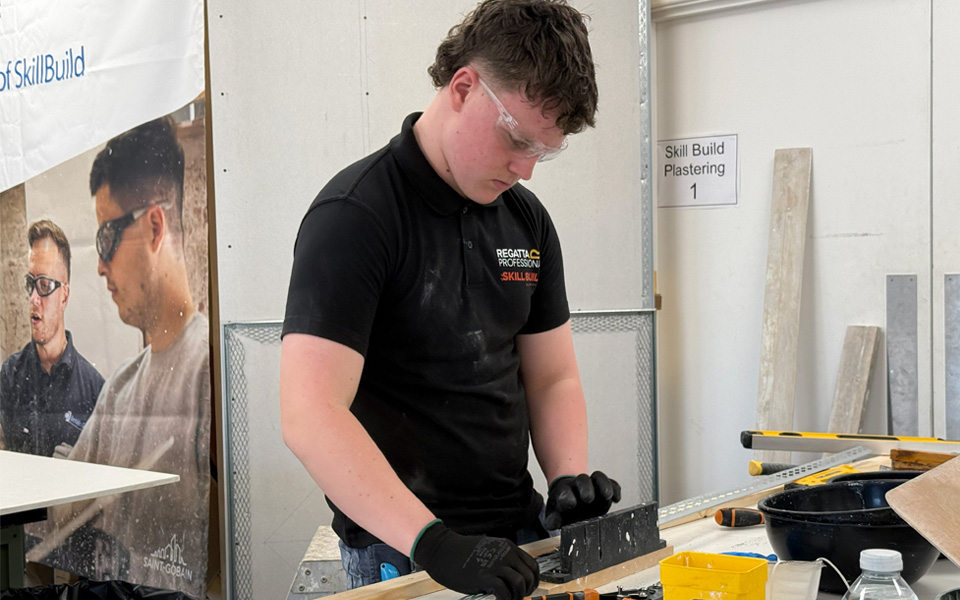 Plastering student using measuring tape