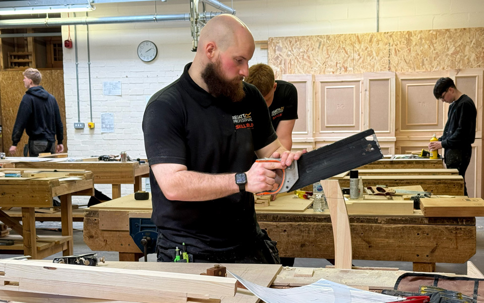 Student in workshop sawing