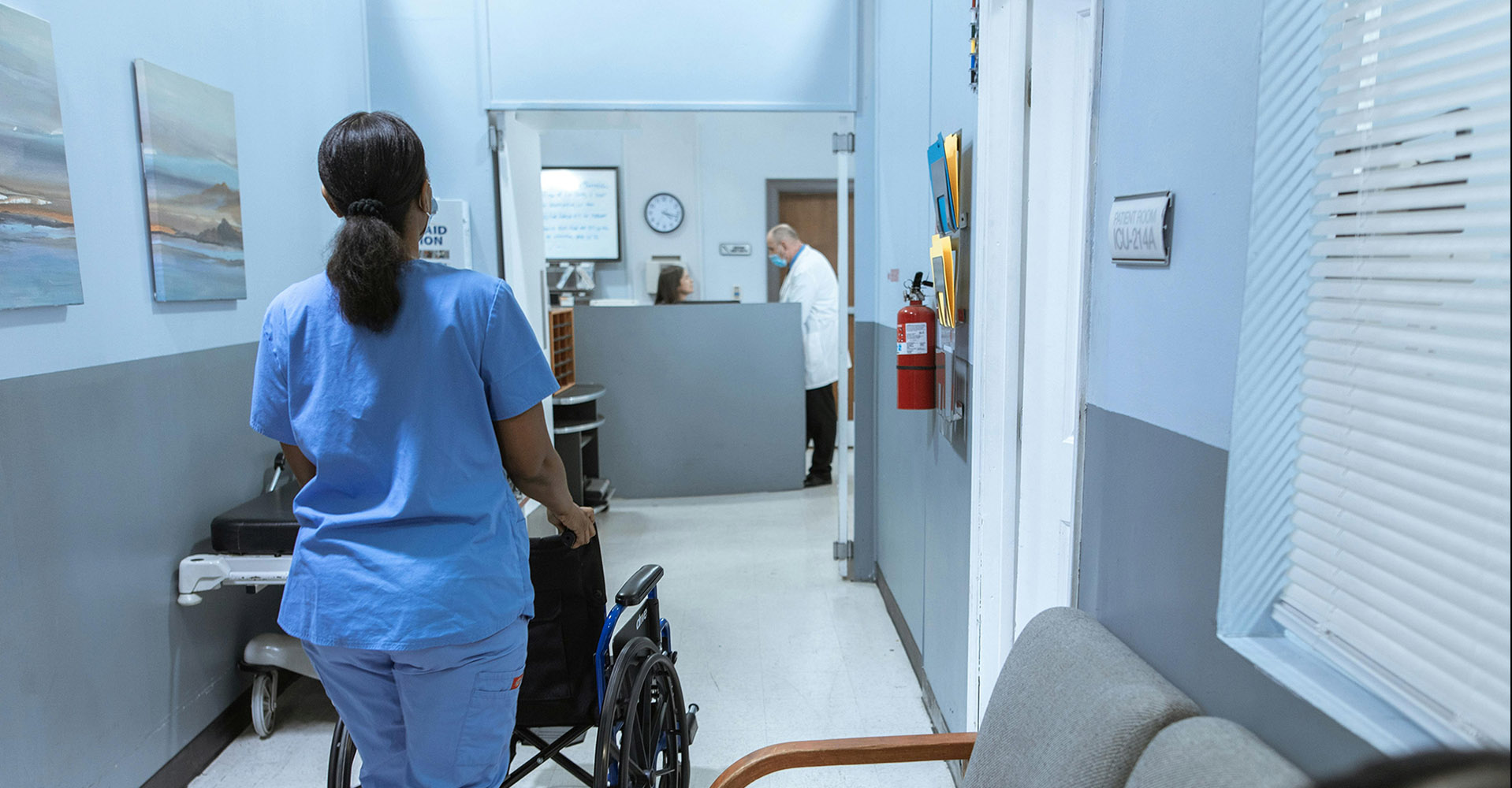 Hospital staff with wheelchair in corridor