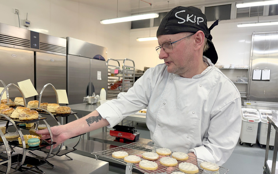 Student placing bakes on afternoon tea stand