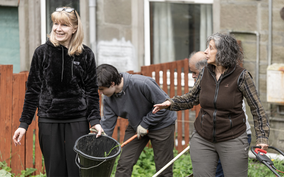 Green Roots Project volunteers walking together with gardening tools