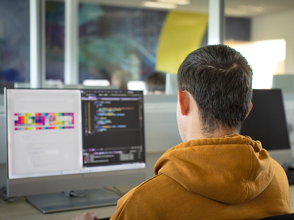 Student writing code in a computing classroom