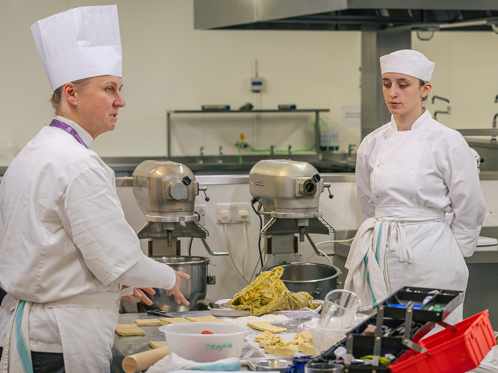 Cookery lecturer explaining her process to students