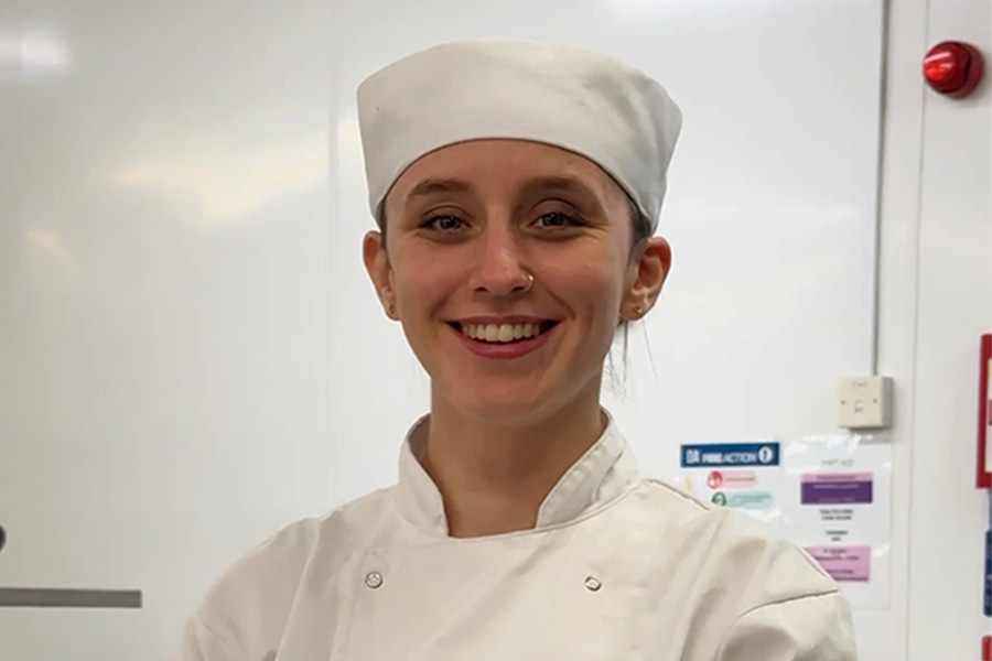 Student in chef whites smiling at camera