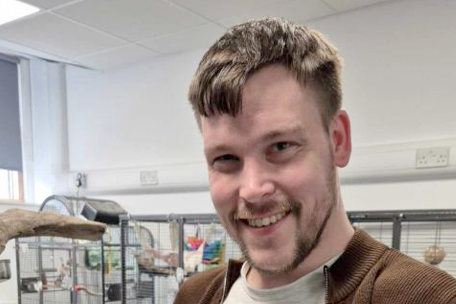 Student smiling at camera in animal care room