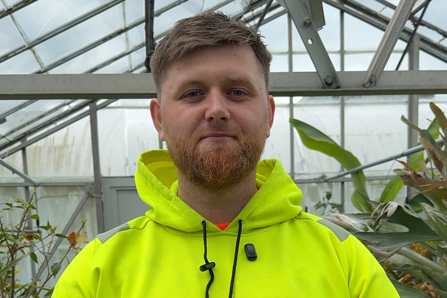 Horticulture student standing in greenhouse smiling